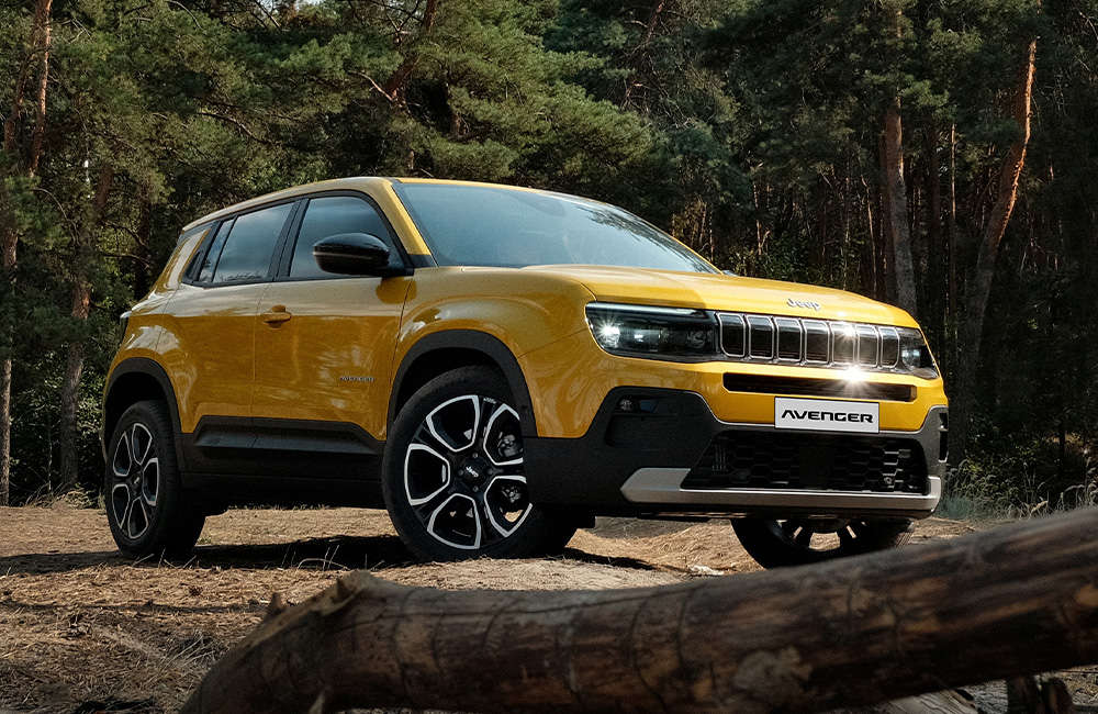 Jeep Avenger e-Hybrid на галявині у сосновому лісі