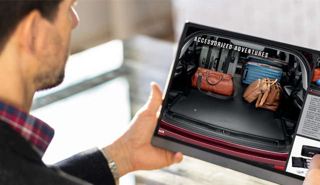 Чоловік тримає в руках планшет з відкритою веб-сторінкою про аксесуари Jeep